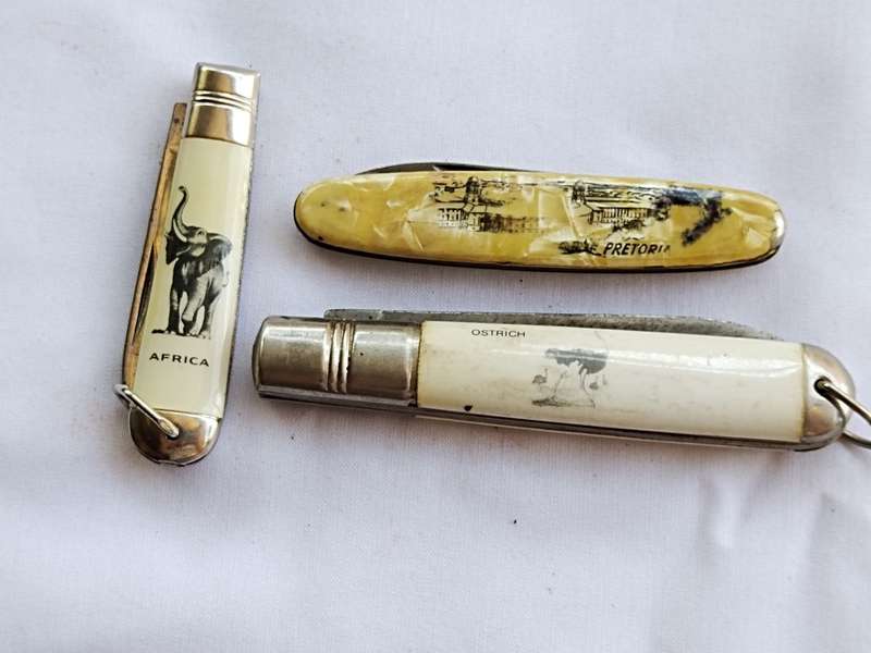 Three vintage pocket knifes two with animals and one union building