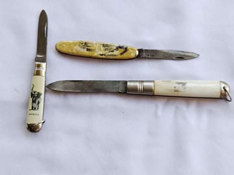 Three vintage pocket knifes two with animals and one union building