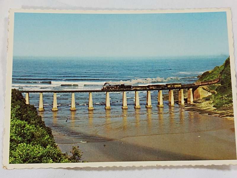 The Railway Bridge spanning the Kaaimans River where it enters the sea. Postcard.