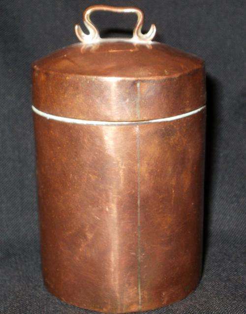 AN OLD COPPER POT WITH LID