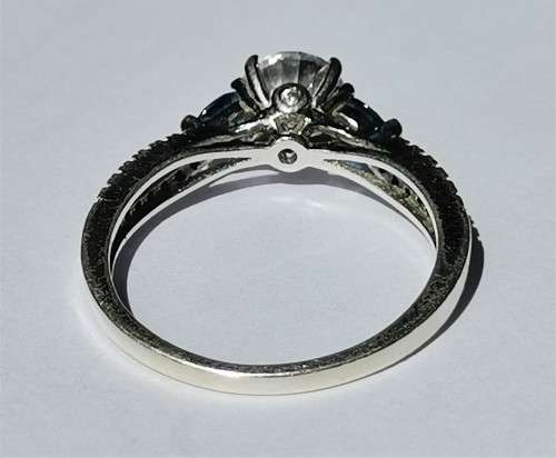 BEAUTIFUL SILVER RING WITH CLEAR MAIN STONE AND TWO BLUE STONES. WEIGHT: 2.5 GRAMS.