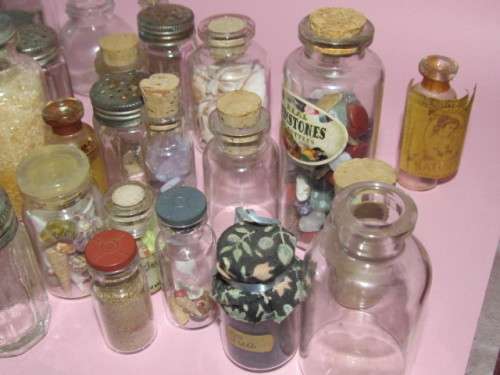 large lot of about 38 small glass bottles - some with labels, some with items inside