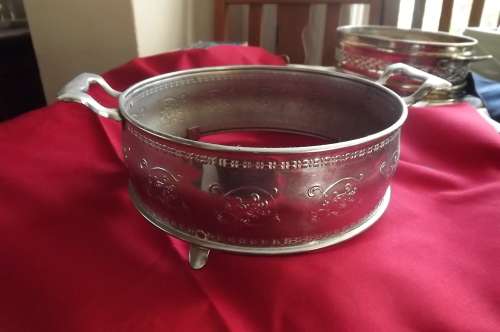 Round chrome plated pot stand with handels.On 4 feet.Good condition. 19 cm diameter.
