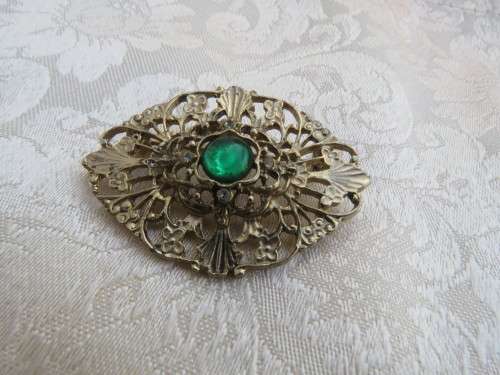 Antique gold toned oval brooch with green stone and 4 tiny zirconias.Excellent condition