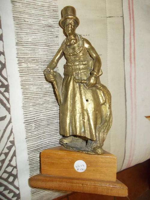 Brass statue on wooden triangle