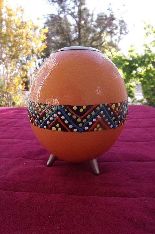 Fabulous African Art Decorated Ostrich Egg standing on little metal feet and candle holder on top