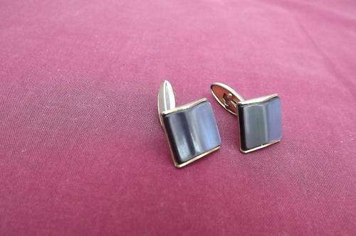 Set of men cuff links with shiny navy stones on gold tone backing. Good condition.