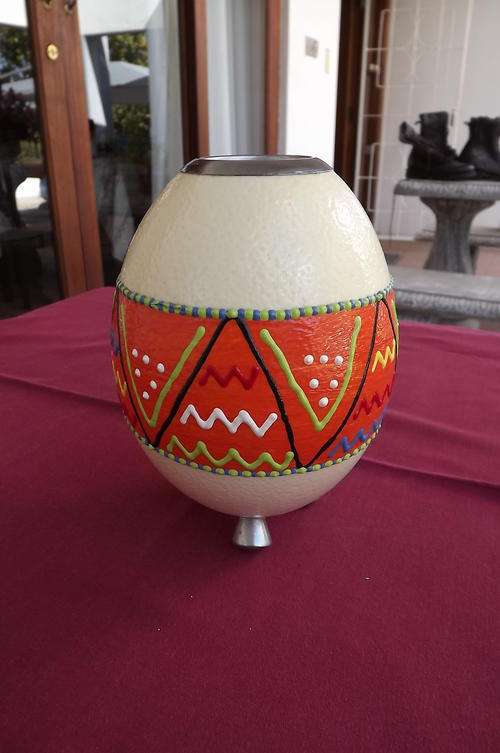 Ostrich egg converted to candle holder.African design pattern painted in bright orange.On feet.New