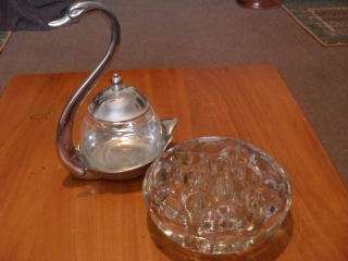A GLASS JAMPOT IN AN EP SWAN STAND AND A HEAVY CUT GLASS FROG