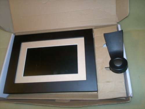 A  7" Digital Picture Frame with Remote, charger, bracket, Wires, books and in good working order.