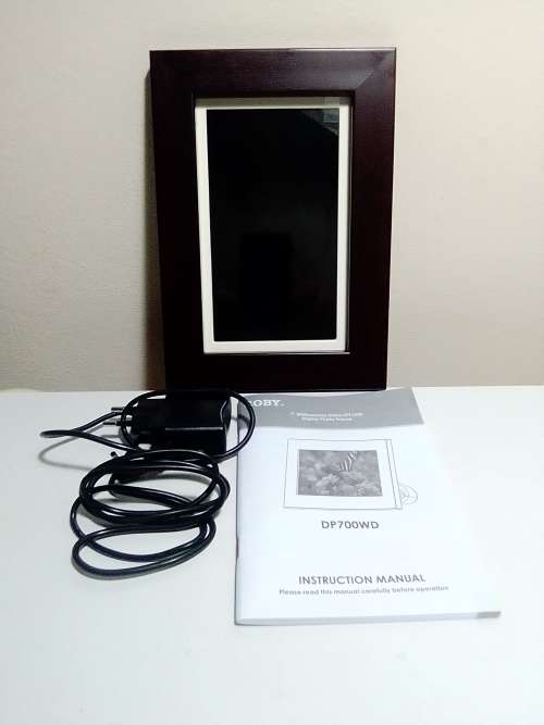 A `Coby` 7 ` Digital photo frame plug in and play with Instructions and Charger in box.