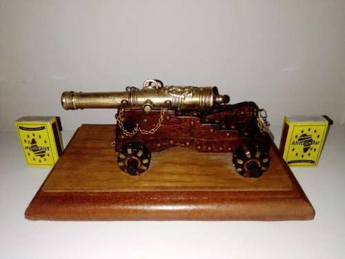 A Brass Canon with crest on Barrel, mounted on a wooden plinth with 4 feet.