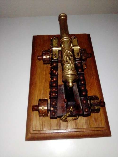A Brass Canon with crest on Barrel, mounted on a wooden plinth with 4 feet.