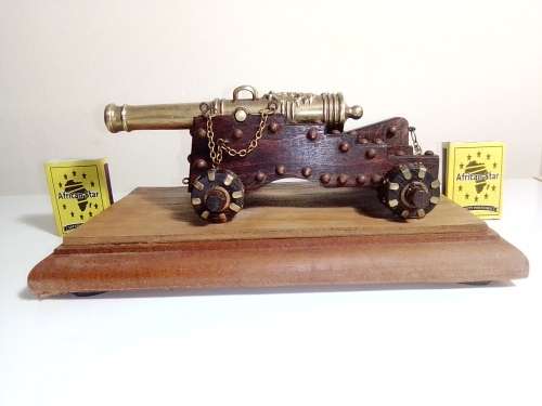 A Brass Canon with crest on Barrel, mounted on a wooden plinth with 4 feet.
