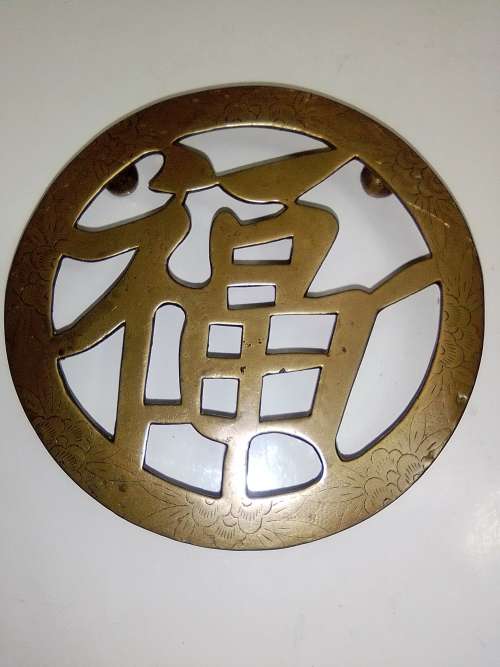 A ornate Brass Pot rest with a Chinese peace/Goodwill sign