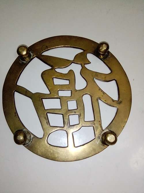 A ornate Brass Pot rest with a Chinese peace/Goodwill sign
