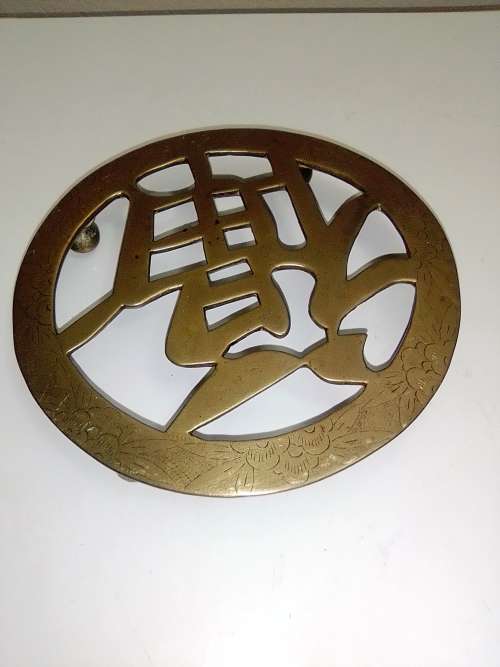 A ornate Brass Pot rest with a Chinese peace/Goodwill sign