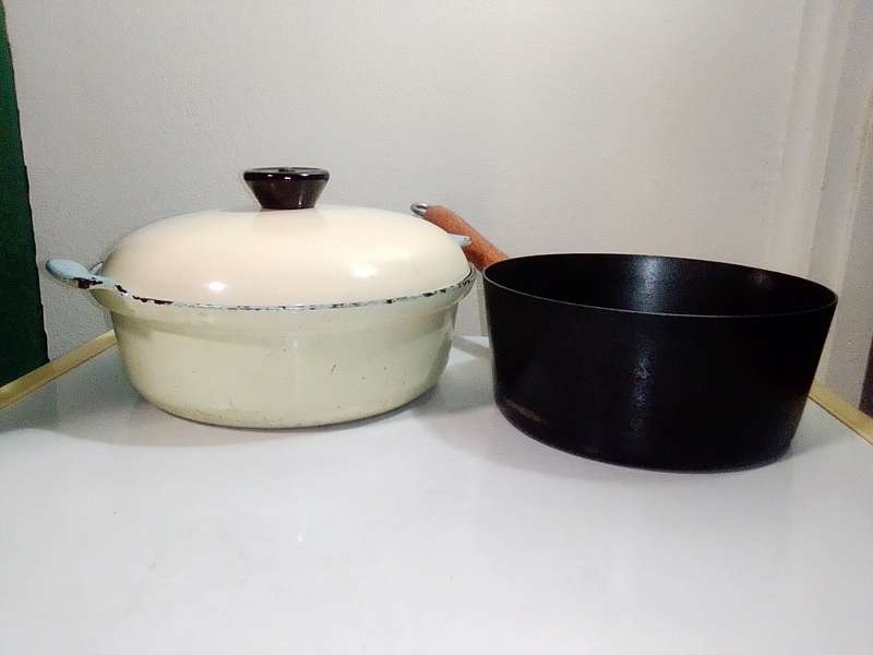 A very old vintage Cookwell blue/cream enamel lidded cooking pot + a cast iron milk boiler.