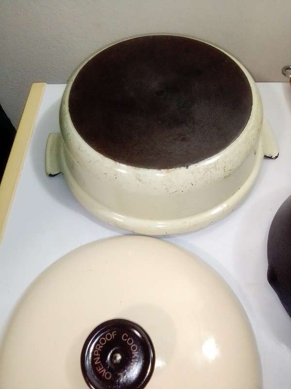 A very old vintage Cookwell blue/cream enamel lidded cooking pot + a cast iron milk boiler.