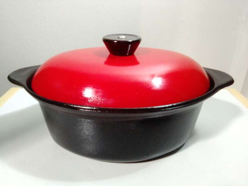 A vintage oval Cookwell Red lidded cast iron cooking pot in good condition.