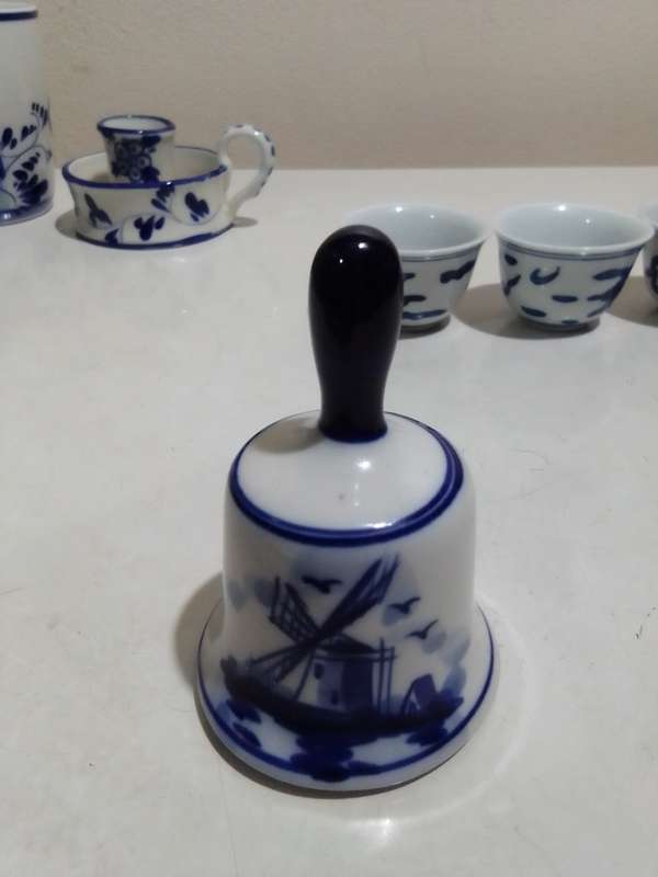 8 x Blue and White items. Delft blue Hand painted Candlestick. Bell with striker. 4 Soike cups.