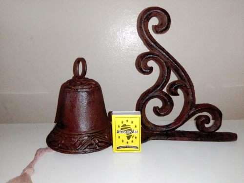 A Old school front door Cast Iron Bell hanging on a nice scrolled bracket.