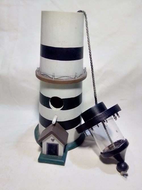 A signed `NCE` Light house bird feeder decoration or use.