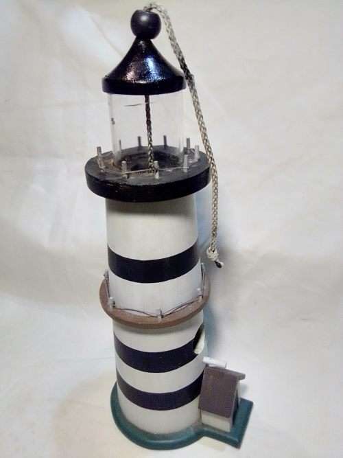 A signed `NCE` Light house bird feeder decoration or use.