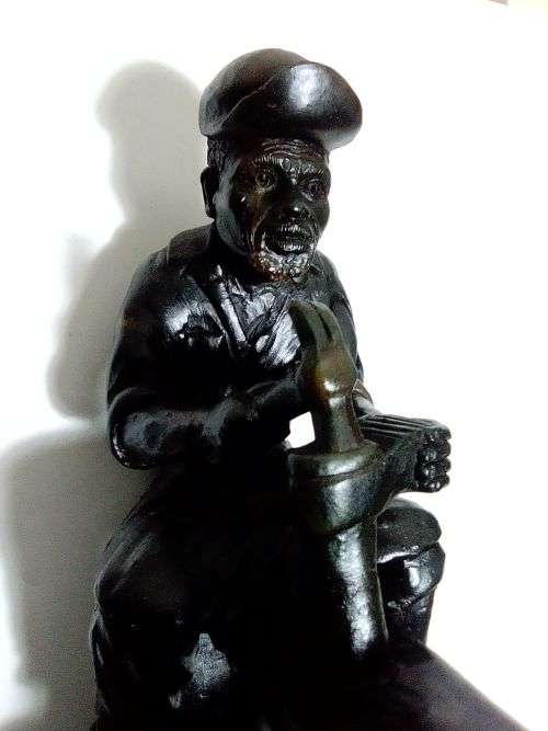 A Very heavy signed By `E. Chiwaridzo` an Ethnic worker, Cobler with hammer and all. 25cm Tall