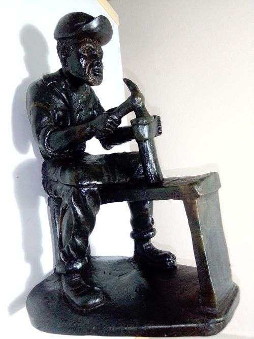A Very heavy signed By `E. Chiwaridzo` an Ethnic worker, Cobler with hammer and all. 25cm Tall