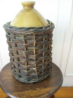 VINTAGE STONEWARE BOTTLE IN BASKET