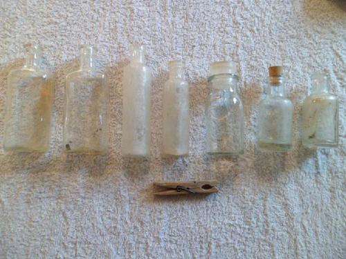 Seven small glass bottles