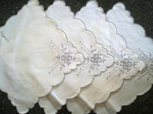 Four cocktail napkins with embroidered corner