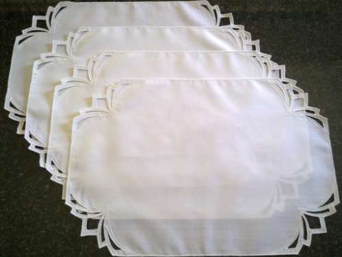 Four white cotton placemats