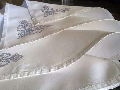 Ten hand embroidered white linen dinner serviettes