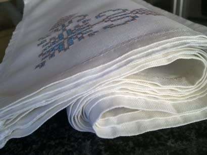 Ten hand embroidered white linen dinner serviettes