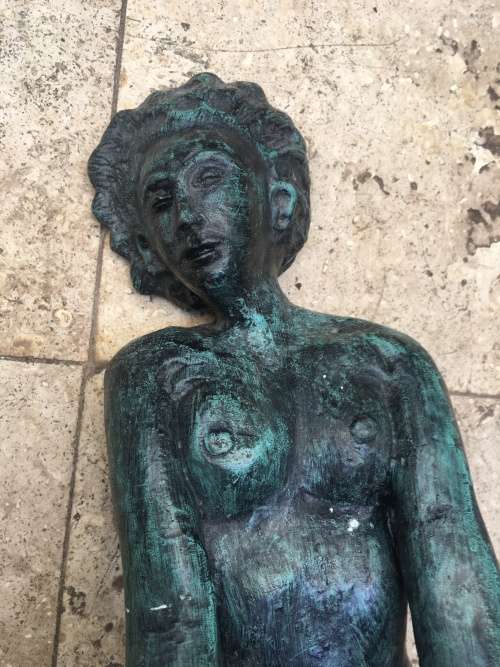 bronze sculpture figure of nude woman laying on back