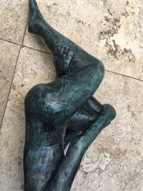 bronze sculpture figure of nude woman laying on back