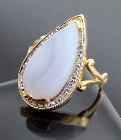 LARGE BLUE LACED AGATE SET IN 14CT YELLOW GOLD WITH WHITE GOLD SURROUND & SMALL DIAMOND ACCENTS.