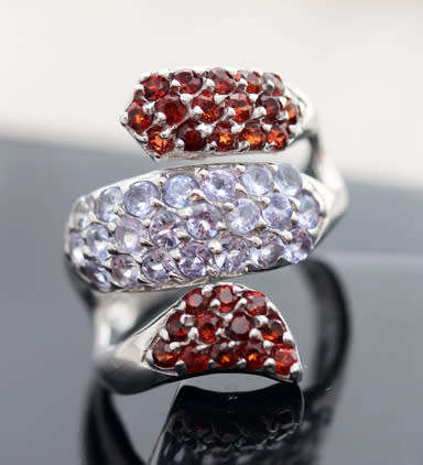 DRAMATIC TRIPLE CROSSOVER STERLING SILVER RING WITH BLUE TANZANITE AND MOZAMBICAN GARNETS. 925