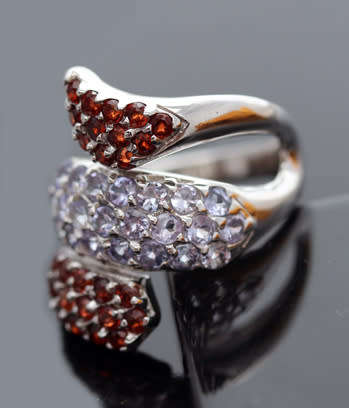DRAMATIC TRIPLE CROSSOVER STERLING SILVER RING WITH BLUE TANZANITE AND MOZAMBICAN GARNETS. 925