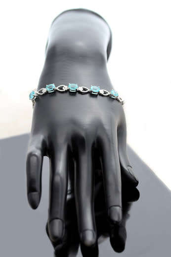 ELEGANT STERLING SILVER BRACELET WITH NEON BLUE APATITE CABOCHON GEMSTONES. DAINTY, OPENWORK DESIGN.