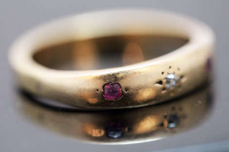 ANTIQUE ENGLISH 9CT GOLD BAND GYPSY SET RUBY AND STAR SET DIAMOND RING. circa early 1900's