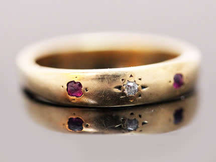 ANTIQUE ENGLISH 9CT GOLD BAND GYPSY SET RUBY AND STAR SET DIAMOND RING. circa early 1900's