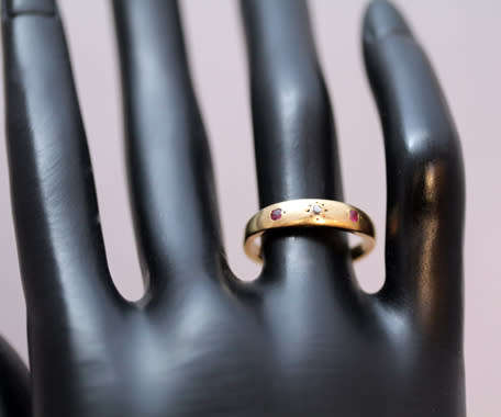 ANTIQUE ENGLISH 9CT GOLD BAND GYPSY SET RUBY AND STAR SET DIAMOND RING. circa early 1900's