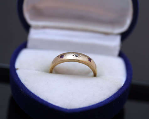 ANTIQUE ENGLISH 9CT GOLD BAND GYPSY SET RUBY AND STAR SET DIAMOND RING. circa early 1900's