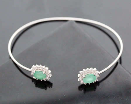 CONTEMPORARY EMERALD AND BRIGHT WHITE STONE STERLING SILVER BANGLE. 925