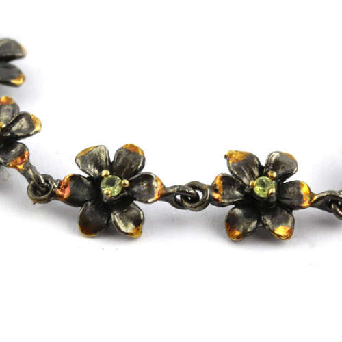 DAINTY FLORAL BRACELET IN GUNMETAL STERLING SILVER WITH PERIDOT CENTRES AND ROSE GOLD-HUED ACCENTS