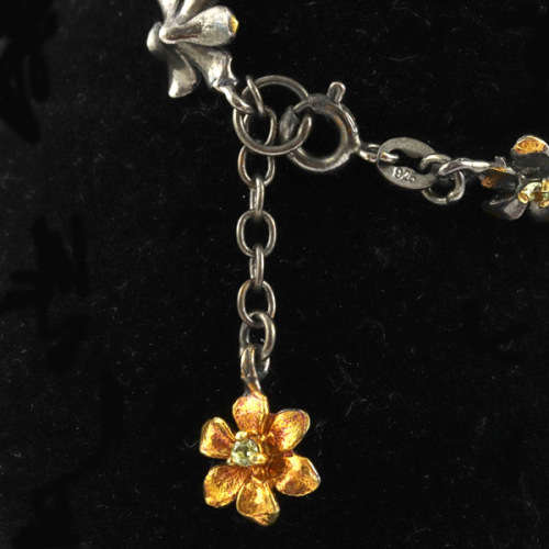 DAINTY FLORAL BRACELET IN GUNMETAL STERLING SILVER WITH PERIDOT CENTRES AND ROSE GOLD-HUED ACCENTS