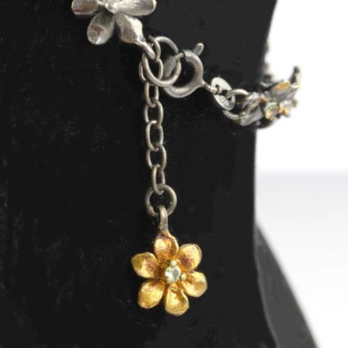 DAINTY FLORAL BRACELET IN GUNMETAL STERLING SILVER WITH PERIDOT CENTRES AND ROSE GOLD-HUED ACCENTS